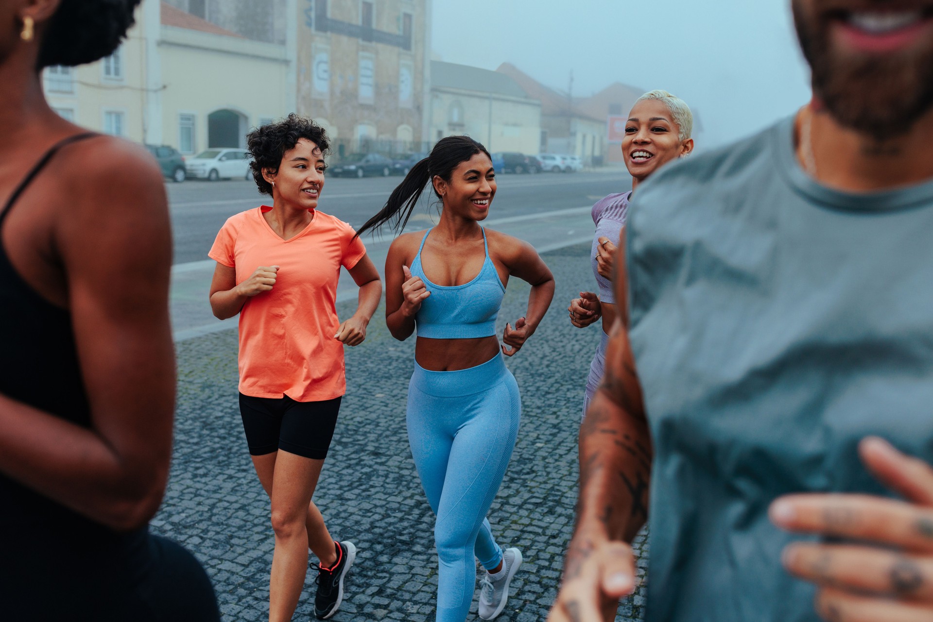 Group of young adults running together in the city